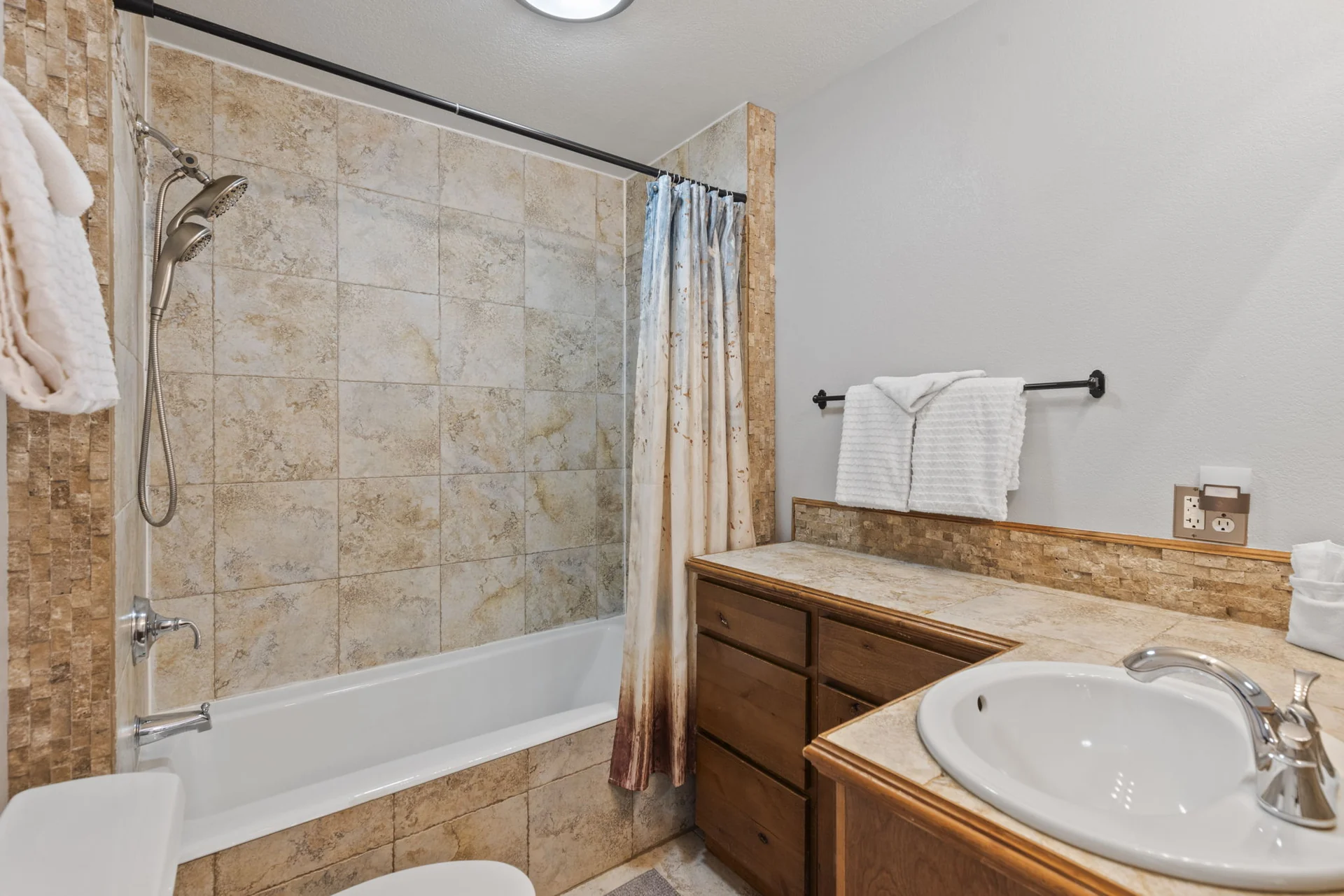 Trailside Retreat, Tiled bathtub and shower beside the wood vanity and sink, luxury vacation rental in Silverthorne, Colorado