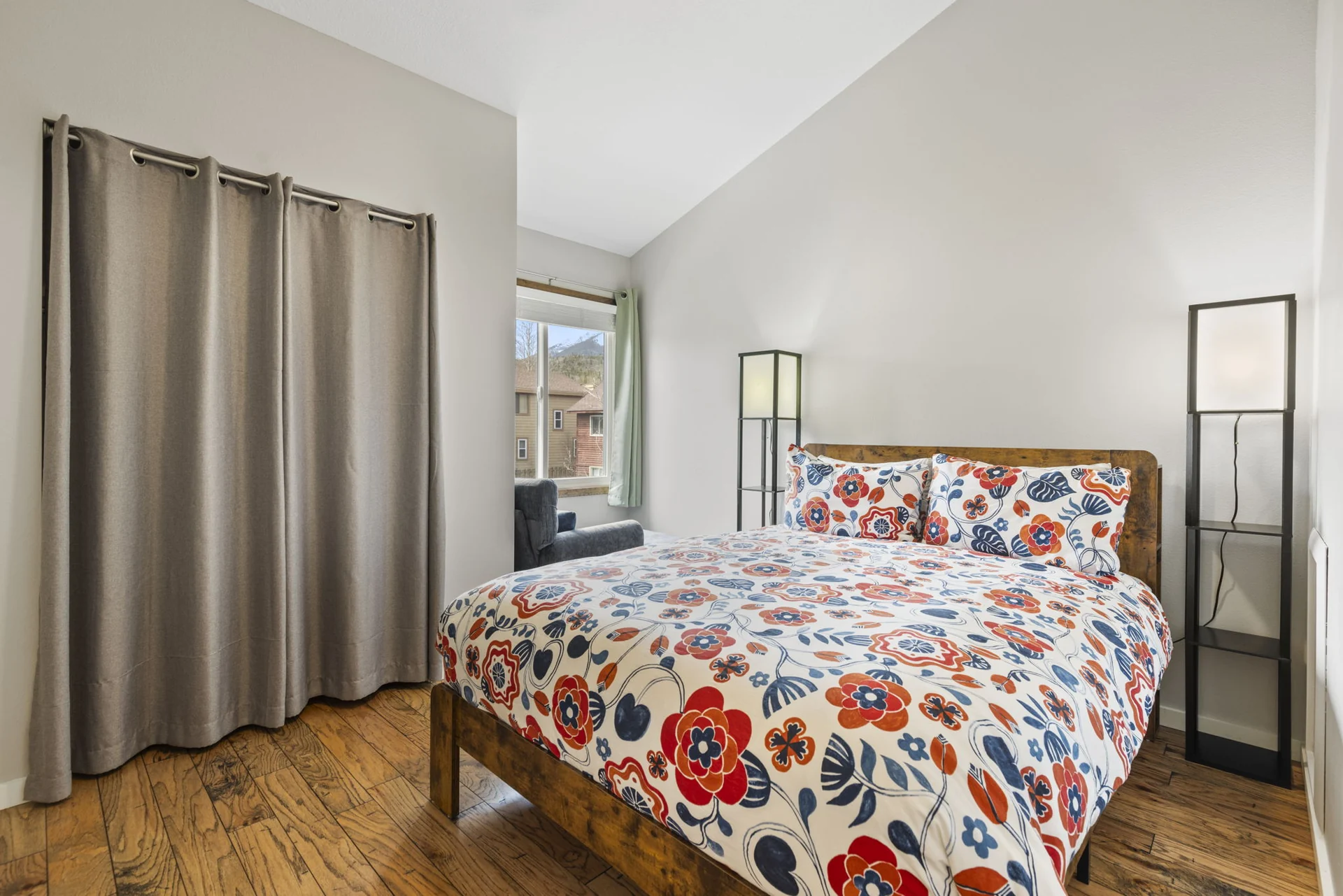 Trailside Retreat, Floral-covered queen bed with floor lamps and curtained window, luxury vacation rental in Silverthorne, Colorado