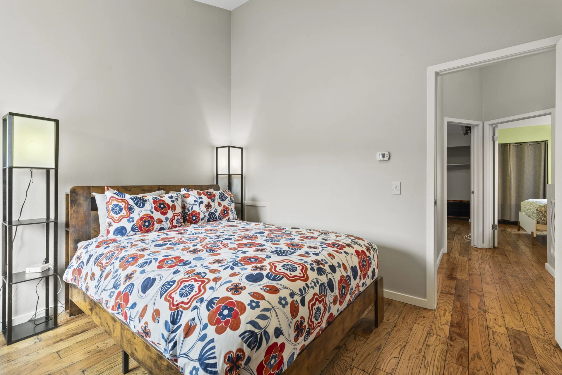 Trailside Retreat, Floral-covered queen bed viewed toward the bedroom doorway, luxury vacation rental in Silverthorne, Colorado