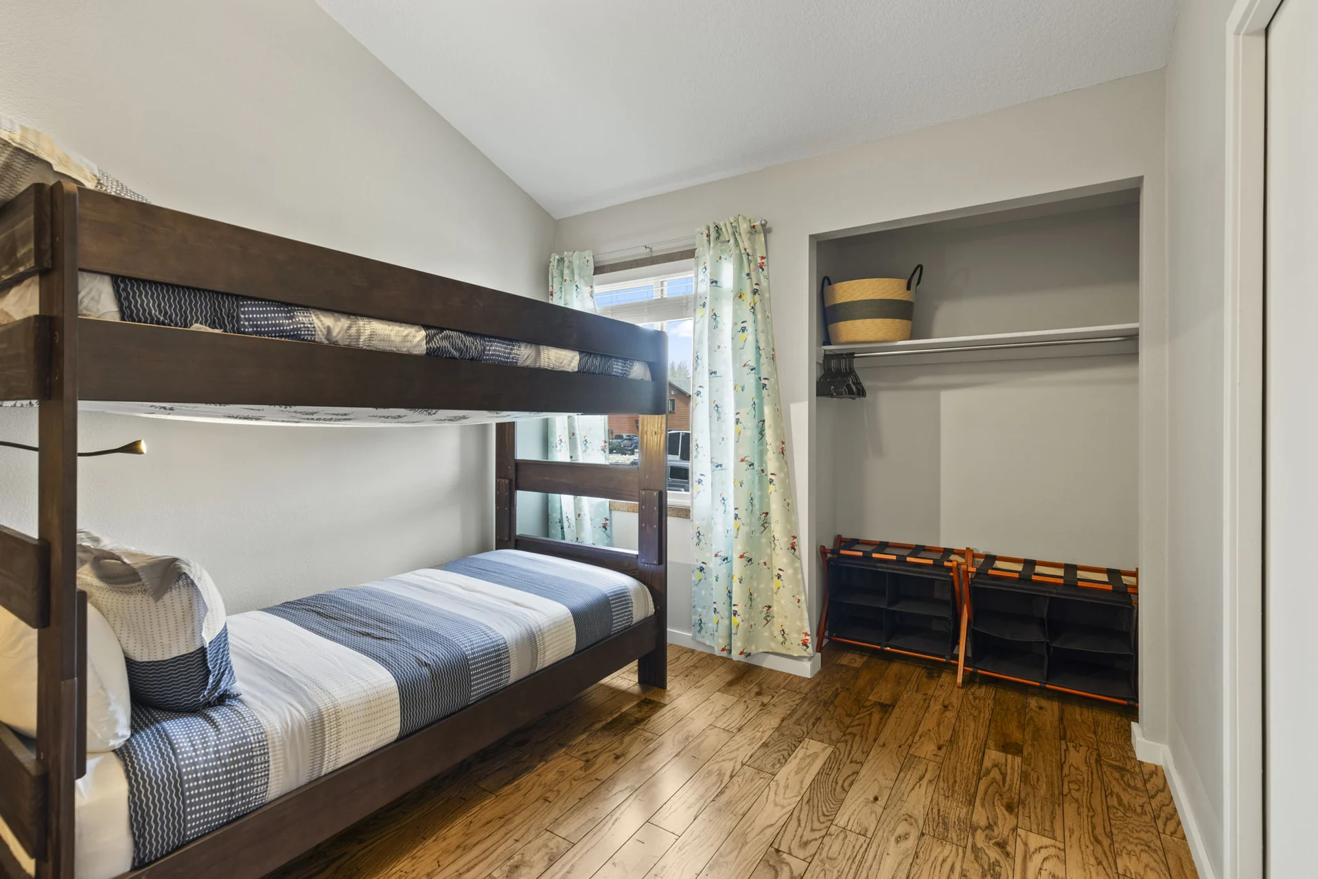Trailside Retreat, Wooden bunk bed with striped bedding beside a window and open closet, luxury vacation rental in Silverthorne, Colorado