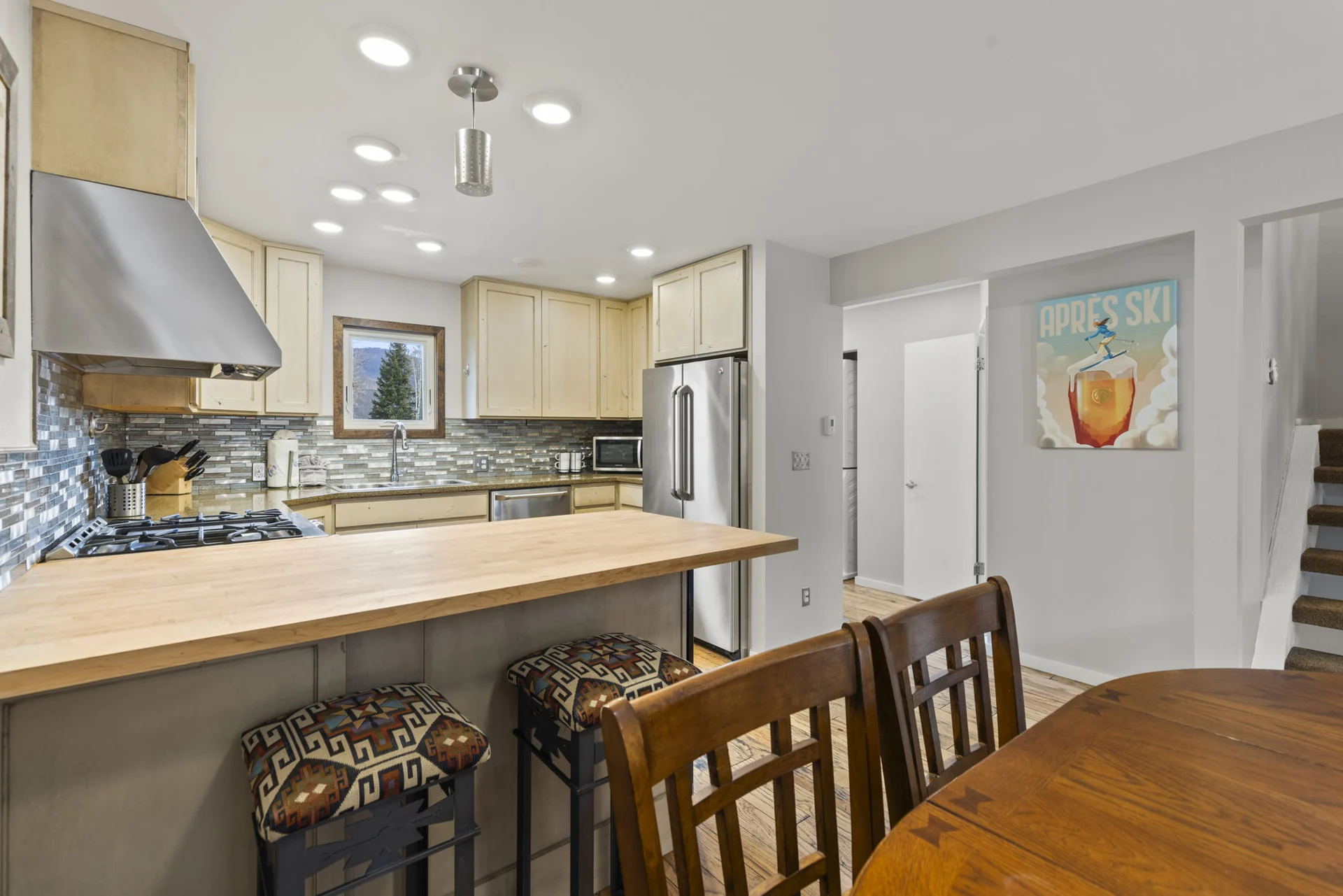 Trailside Retreat, Kitchen island with two stools beside the dining table, luxury vacation rental in Silverthorne, Colorado