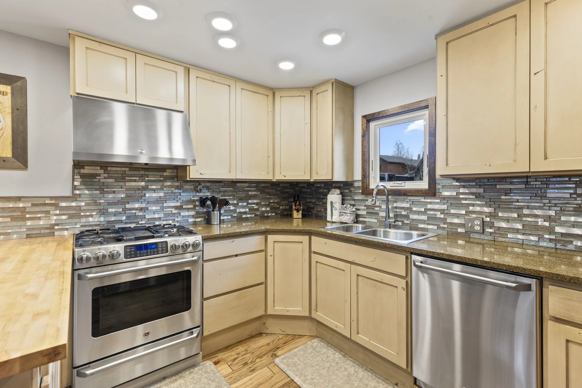 Trailside Retreat, Kitchen range, dishwasher, sink, pale cabinets, and mosaic backsplash, luxury vacation rental in Silverthorne, Colorado