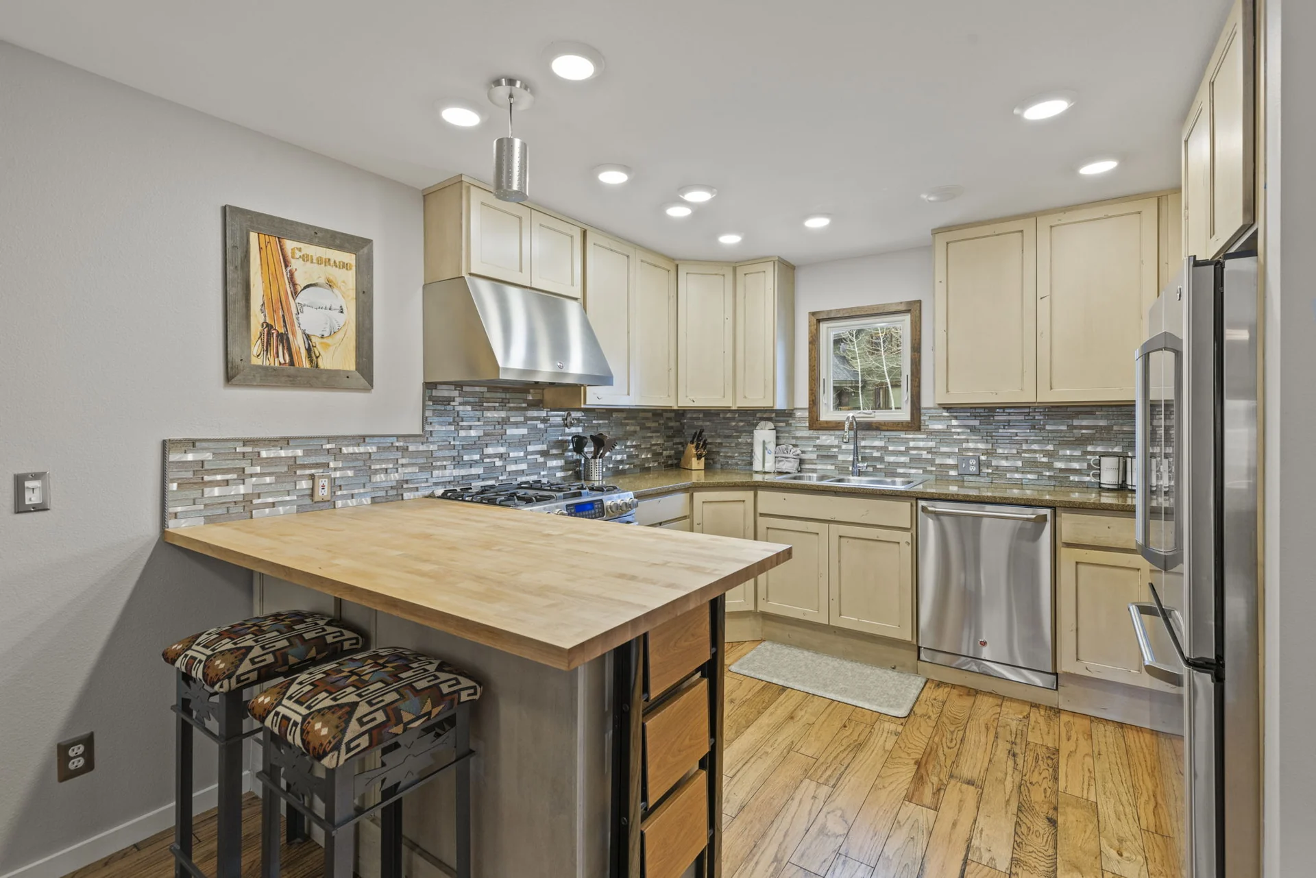 Trailside Retreat, Wood-topped kitchen island and pale cabinetry with stainless appliances, luxury vacation rental in Silverthorne, Colorado