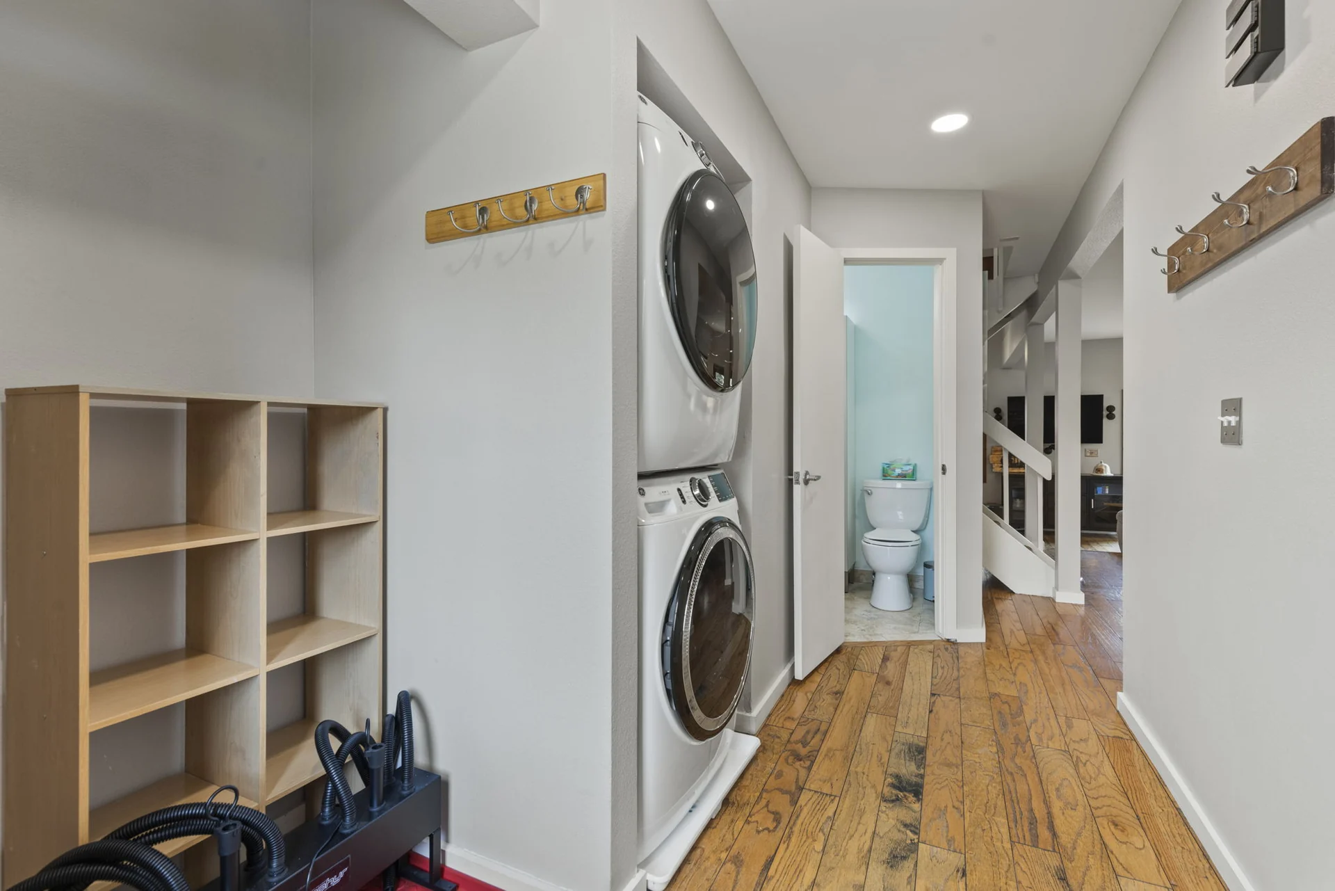 Trailside Retreat, Stacked washer and dryer beside shelves and wall hooks, luxury vacation rental in Silverthorne, Colorado