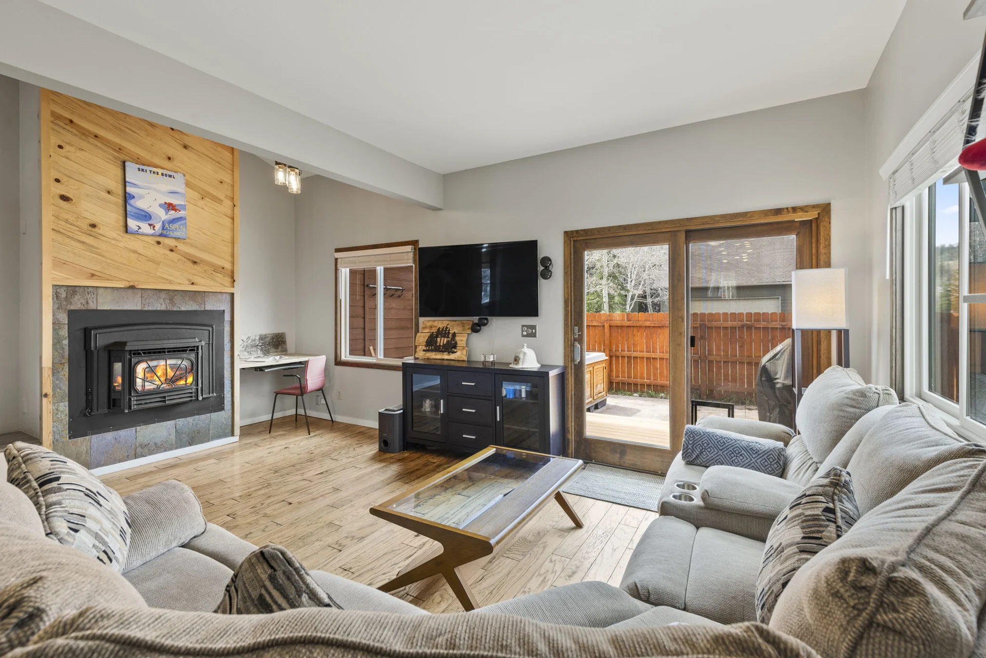 Trailside Retreat, Sectional and glass coffee table facing the fireplace and patio doors, luxury vacation rental in Silverthorne, Colorado