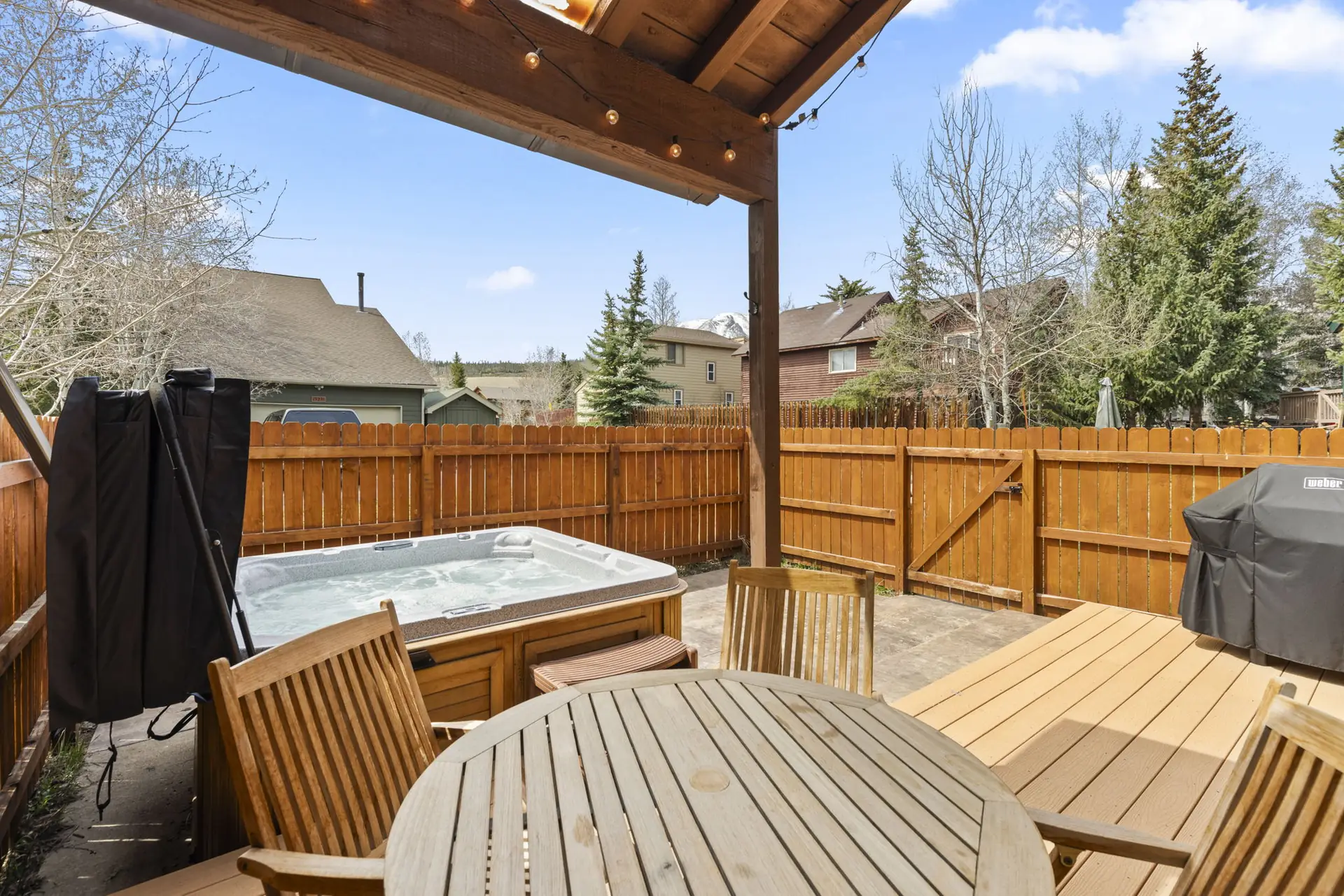 Trailside Retreat, Outdoor table and chairs beside hot tub and covered grill, luxury vacation rental in Silverthorne, Colorado