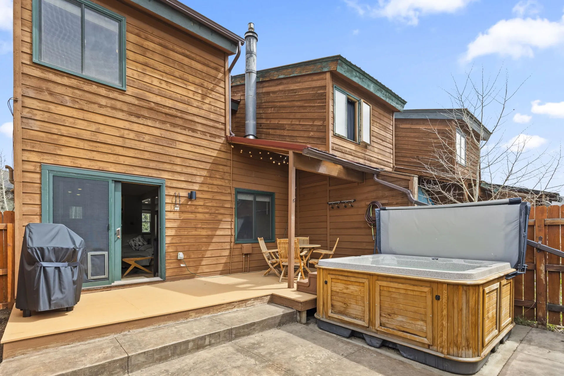 Trailside Retreat, Wood-sided home opening onto covered patio with grill and hot tub, luxury vacation rental in Silverthorne, Colorado