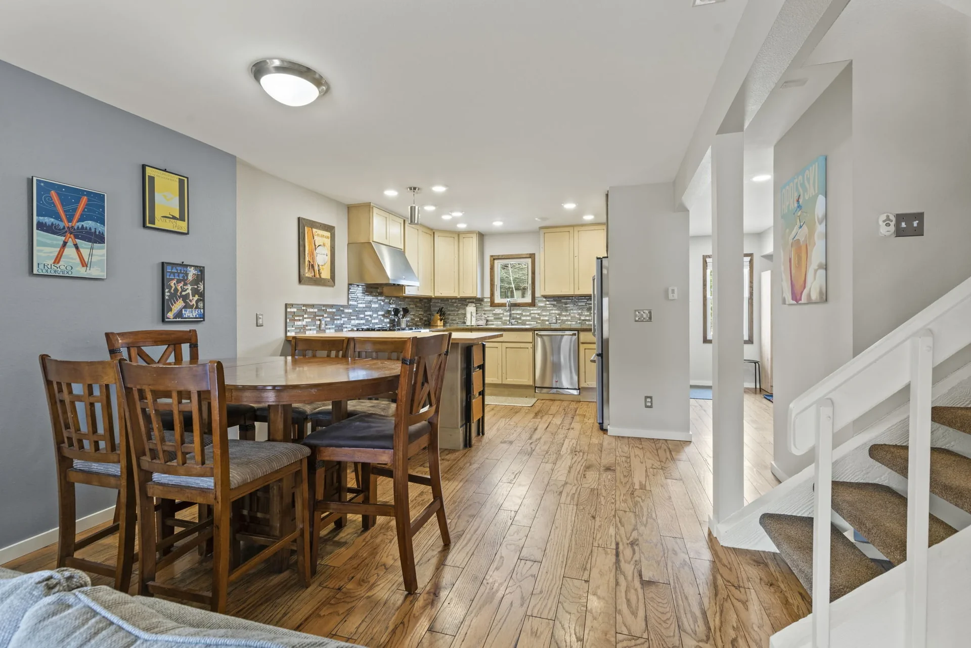 Trailside Retreat, Round wood dining table beside the kitchen and staircase, luxury vacation rental in Silverthorne, Colorado